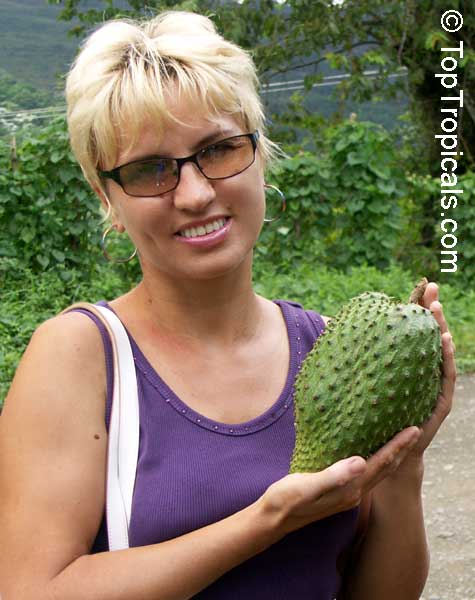 A blonde girl holding Soursop, Guanabana fruit