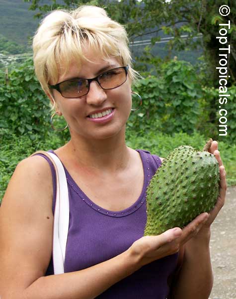 A blonde girl holding Soursop, Guanabana  FRUIT